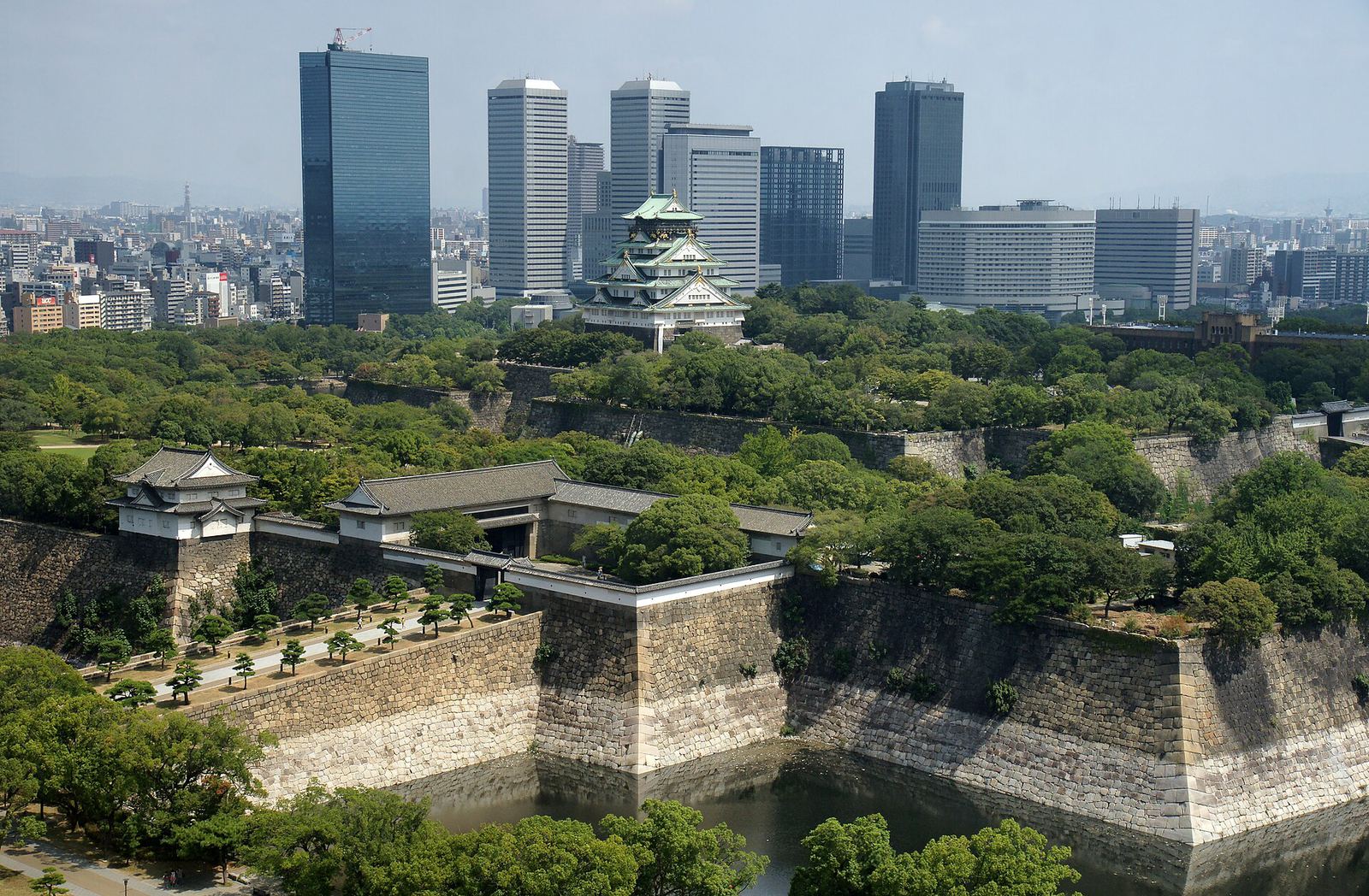 Osaka Castle surrounded by trees and a wide moat